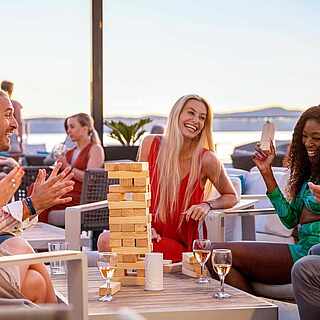 Gruppe von Urlaubern spielt Jenga